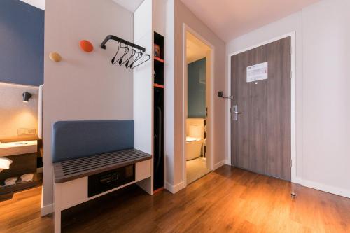 a room with a tv and a hallway with a door at Holiday Inn Express Shanghai Tangzhen by IHG - 20 mins to PVG Airport and Disney land in Shanghai
