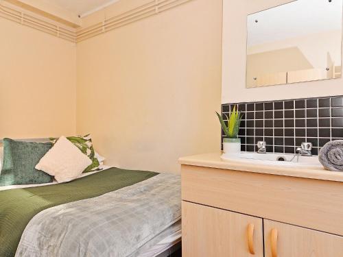 a bedroom with a bed and a sink at For Students Only Pirvate Ensuites and Non-Ensuite Rooms with Shared Bathroom at St Andrews Gardens in Liverpool in Liverpool