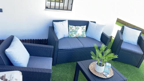 eine Terrasse mit zwei blauen Korbstühlen und einem Tisch in der Unterkunft MARAVILLOSO DUPLEX EN ÍTRABO in Ítrabo