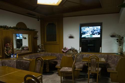 un restaurante con mesa y TV en la pared en Garnì Centrale, en Roncone