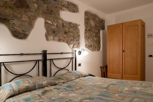 1 dormitorio con 1 cama y puerta de madera en Garnì Centrale, en Roncone