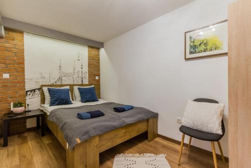 Un dormitorio con una cama con almohadas azules y una silla en Charming Central Residence by NeWave Apartments en Budapest
