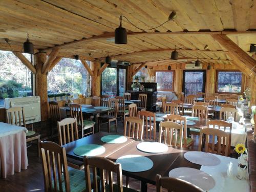 Ośrodek Wypoczynkowy MAX في جرنلتويك: غرفة طعام مع طاولات وكراسي خشبية