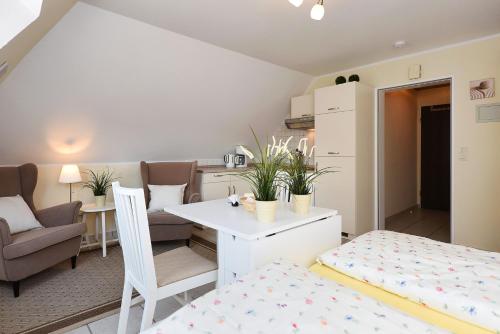 a small room with a bed and a table and chairs at Apartment Typ C im DG, Haus Friedeburg, Carolinensiel in Wittmund
