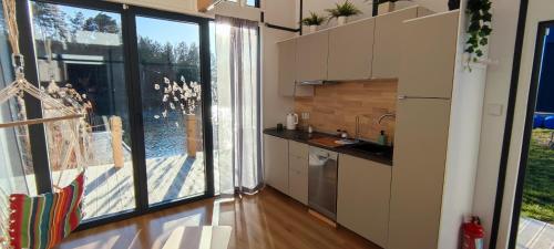 une cuisine avec une grande fenêtre et une cuisine avec un évier dans l'établissement Stawy u Sikory Domek Czapla, à Bledzew