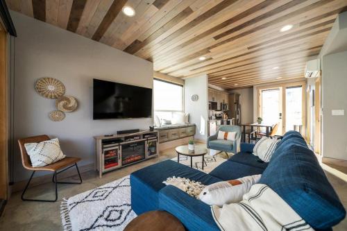 a living room with a blue couch and a tv at Rum Away with Me #303 in Chelan