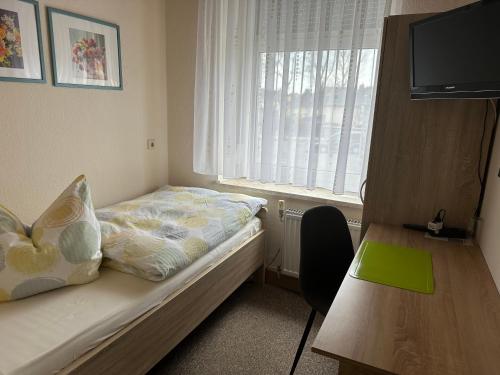ein kleines Schlafzimmer mit einem Bett und einem Fenster in der Unterkunft Gasthof „Zum Schwan“ in Langenbach