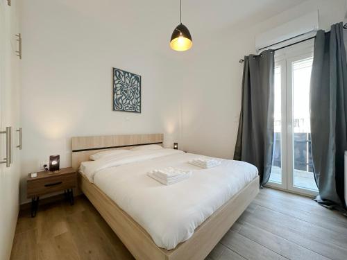 um quarto com uma cama grande e uma janela em Santa Barbara C1 Cityscape 68sqm apt in Nea Smirni em Atenas