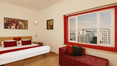 1 dormitorio con cama, ventana y silla en Red Fox Hotel, Hitech city, Hyderabad, en Hyderabad