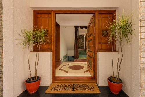 two potted plants sitting in front of a door at Villa 9C by Revkeys in Bengaluru