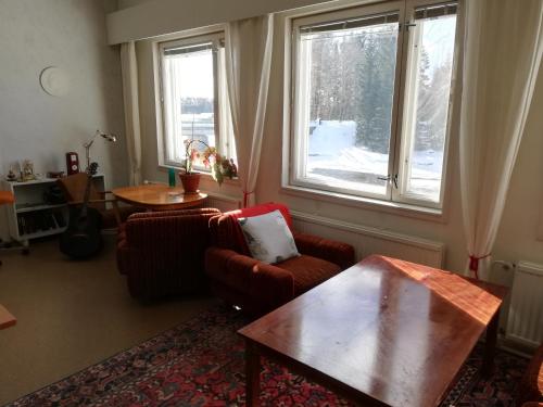 uma sala de estar com duas cadeiras, uma mesa e uma janela em Kattilakosken vanha Pappila em Kärsämäki