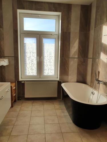 a bathroom with a tub and a window at Gamleby Hotell in Gamleby
