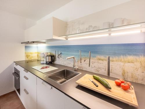 a kitchen with a sink and a counter with a view of the beach at Gut Vorwerk in Sagard
