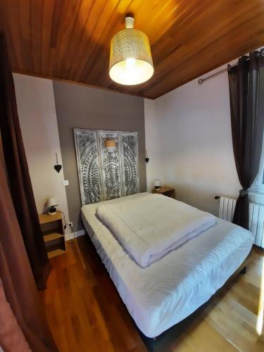 a bedroom with a large bed with a wooden ceiling at le pigeonnier in Le Tréport