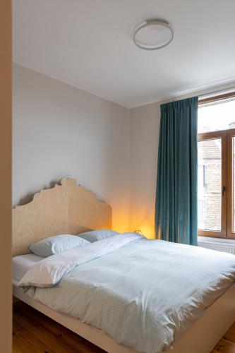 a bedroom with a large white bed with a window at 3 Queens in Bruges