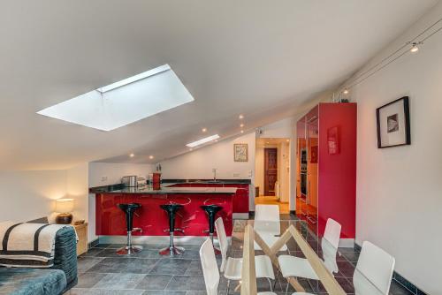 un salon avec une table et une cuisine rouge dans l'établissement APARTMENT LES DRUS - Alpes Travel - Chamonix - Sleeps 6, à Chamonix-Mont-Blanc