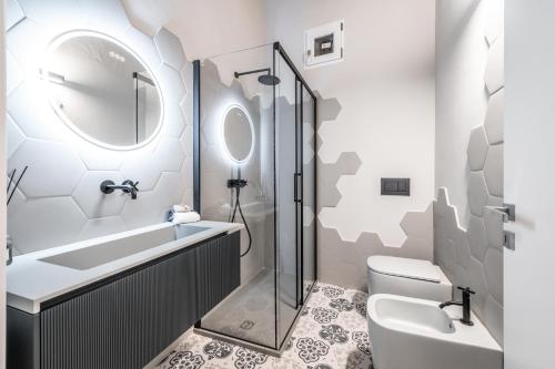 La salle de bains est pourvue de toilettes, d'un lavabo et d'une douche. dans l'établissement Emilia Suite Palace, à Modène