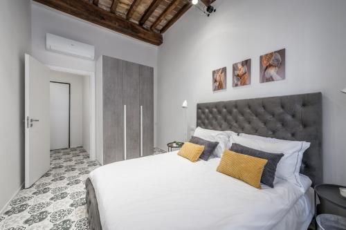 - une chambre avec un grand lit blanc et des oreillers jaunes dans l'établissement Emilia Suite Palace, à Modène