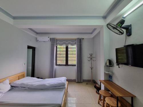 een slaapkamer met 2 bedden, een tafel en een raam bij NHÀ NGHỈ T&T in Dồng Văn