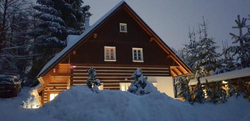 a house with a pile of snow in front of it at BP Chata Ostružná in Ostružná
