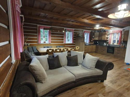 a living room with a large couch in a room at BP Chata Ostružná in Ostružná