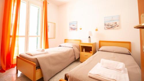 two beds in a room with a window at Appartamento l'Ulivo in Cala Gonone