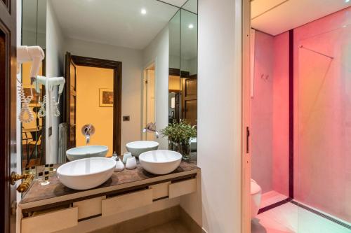 uma casa de banho com 2 lavatórios e um espelho em DEZA cozy place Nazionale em Roma