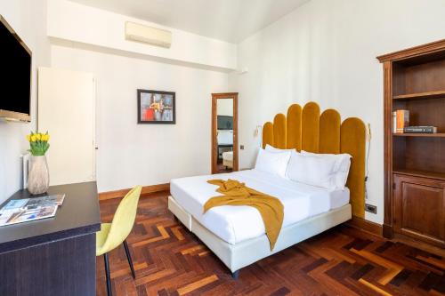 sypialnia z łóżkiem, biurkiem i telewizorem w obiekcie DEZA cozy place Nazionale w Rzymie