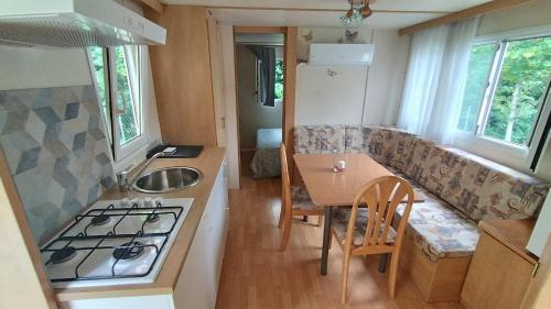 eine kleine Küche mit Sofa und Tisch in einem winzigen Haus in der Unterkunft Il Cinisco in Frontone