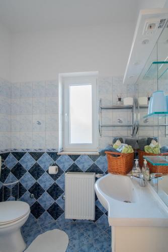 a bathroom with a toilet and a sink at Hotel Villa Vera in Fažana