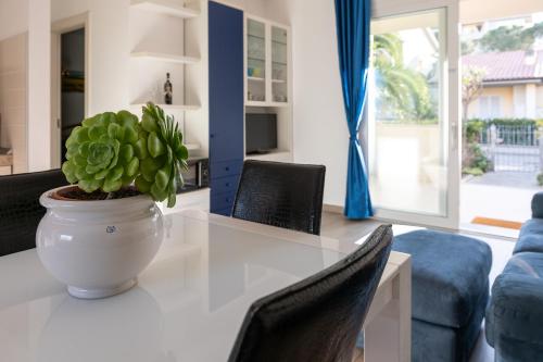 a white table with a potted plant on top of it at Casa Pineta in Follonica