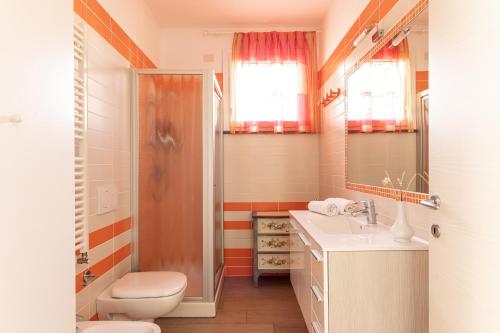 a bathroom with a toilet and a sink and a shower at Casa Pineta in Follonica