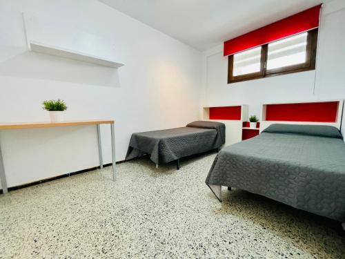 een slaapkamer met 2 bedden, een tafel en een raam bij COSTA DAURADA APARTAMENTS - Formentor 736 in Salou