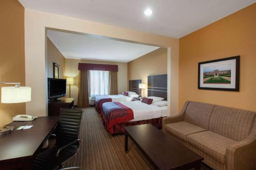 a hotel room with two beds and a desk at Wingate By Wyndham Houston / Willowbrook in Houston