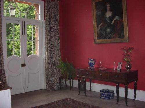 a room with a table and a painting and a door at Glebe House Muston in Muston