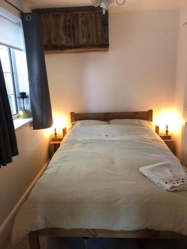 a bedroom with a large bed with two lamps at Loughor Annnex, Llangennech , Wales in Llangennech