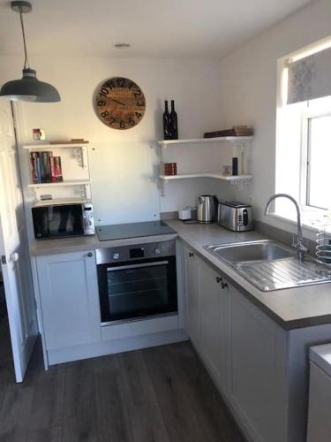 a kitchen with a sink and a stove top oven at Loughor Annnex, Llangennech , Wales in Llangennech