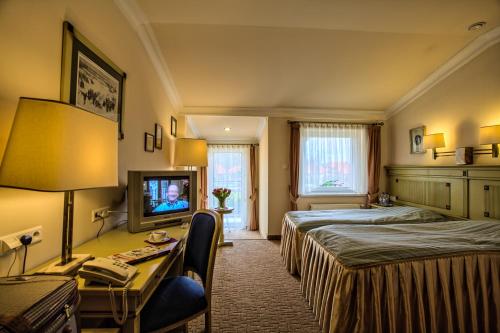 a hotel room with two beds and a television at Hotel na Podzamczu in Tarnowskie Góry
