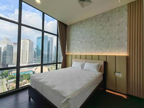 a bedroom with a large bed and large windows at Senopati Penthouse Luxury 2 Bedroom Full Furnished SCBD Area in Jakarta