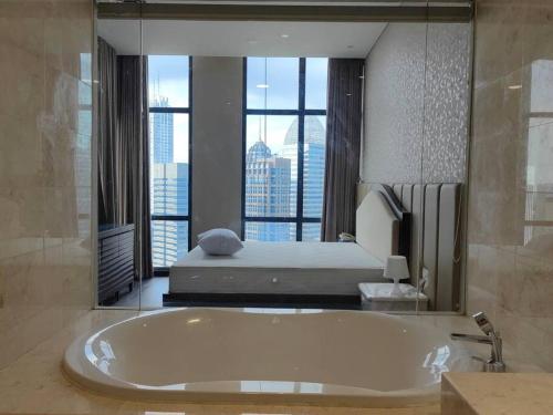 a large bathroom with a large tub and a bed at Senopati Penthouse Luxury 2 Bedroom Full Furnished SCBD Area in Jakarta