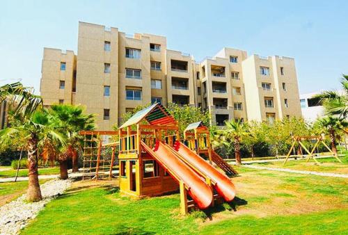 a playground with a bunch of slides and a building at New Cairo Modern Apartment in Cairo