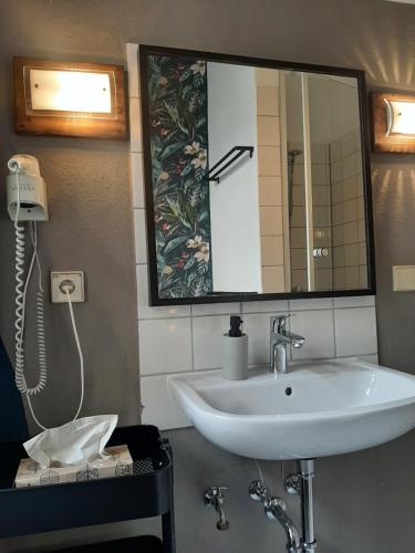 a bathroom with a sink and a mirror at Hostel Lollis Homestay Dresden in Dresden