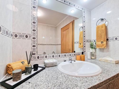 a white bathroom with a sink and a mirror at Apartment Rocha Varandas Atlantis in Portimão