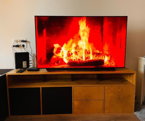 a tv sitting on a stand with a fire in it at Blue Sky in Koper