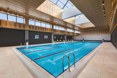 a large swimming pool in a large building at Wyndham Garden Baku in Baku