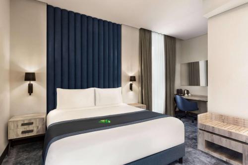 a hotel room with a bed and a desk at Wyndham Garden Baku in Baku