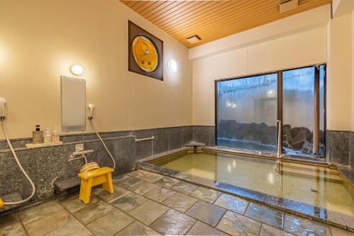 uma piscina num quarto com um relógio na parede em Ichinoyu Shinkan em Hakone