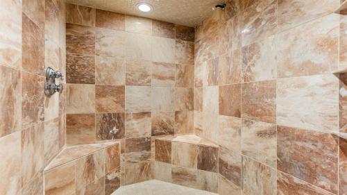 a bathroom with a large shower with brown tiles at Bayside Townhome In Diamond Beach! in Wildwood Crest