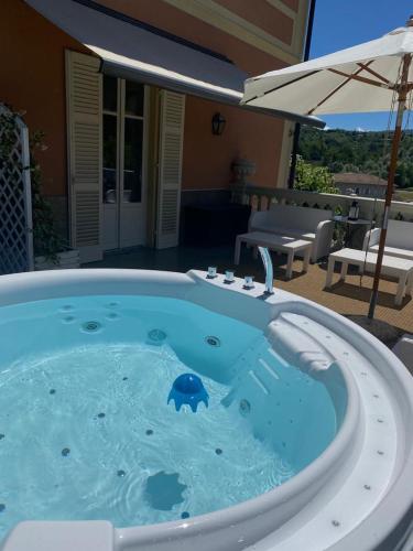 a large hot tub in a yard with an umbrella at Duchessa Margherita Chateaux & Hotels in Vicoforte