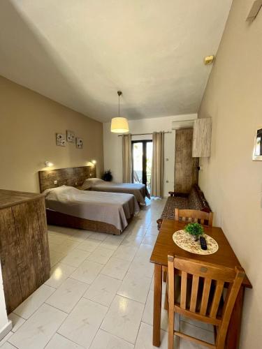 a hotel room with two beds and a table and a dining room at Kydonia apartments in Plataniás